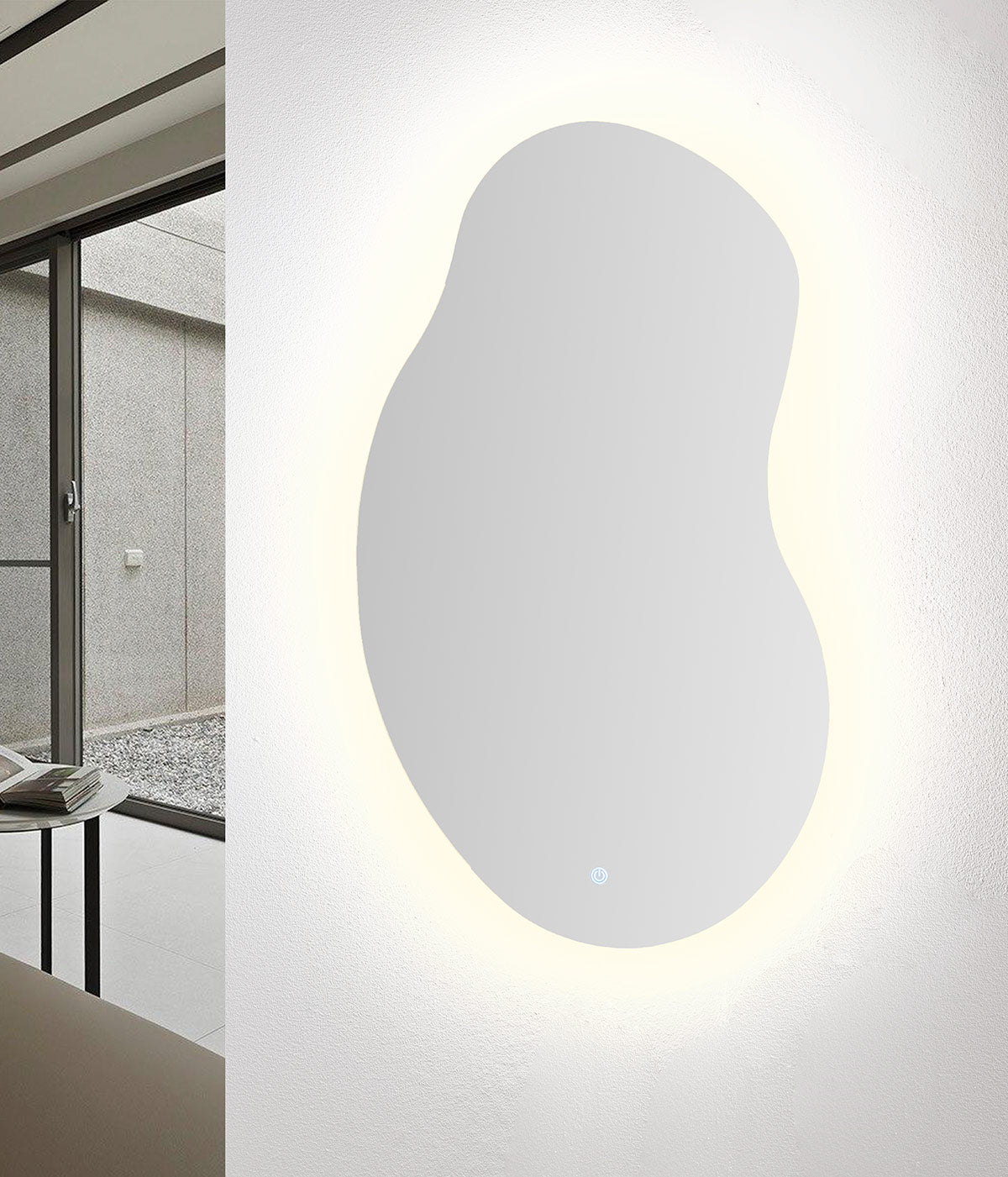 Espejo Nebula sin marco, diseño orgánico moderno con silueta fluida, botón táctil y retroiluminación LED perimetral para baño o vestidor.