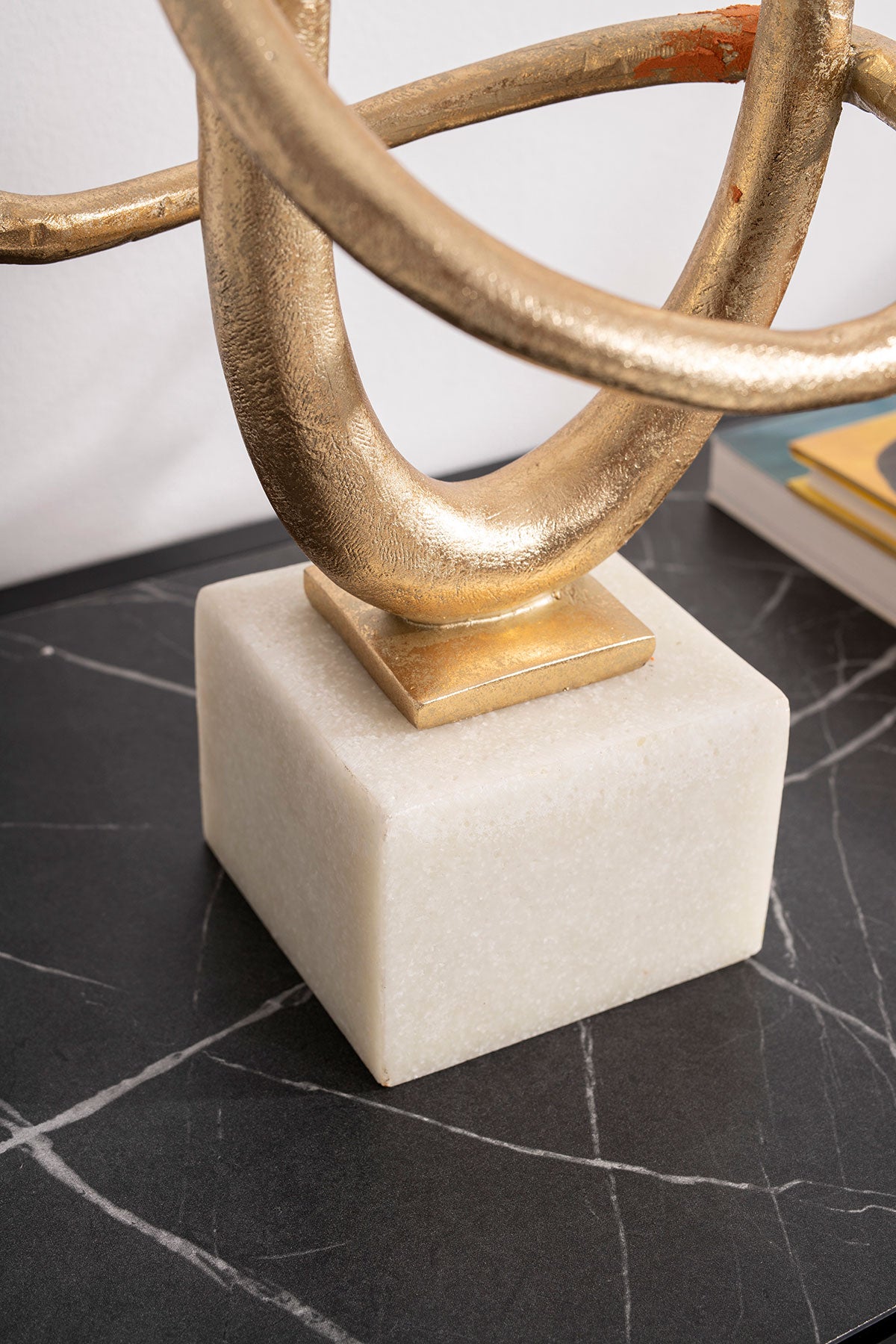 Escultura Ariadne abstracta de metal dorado sobre base de mármol blanco. Diseño vanguardista para decoración contemporánea, 22x22x49 cm.