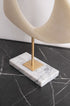 Escultura abstracta Cyclades en piedra blanco roto y soporte dorado sobre mármol veteado. Ideal para decoración minimalista o contemporánea.