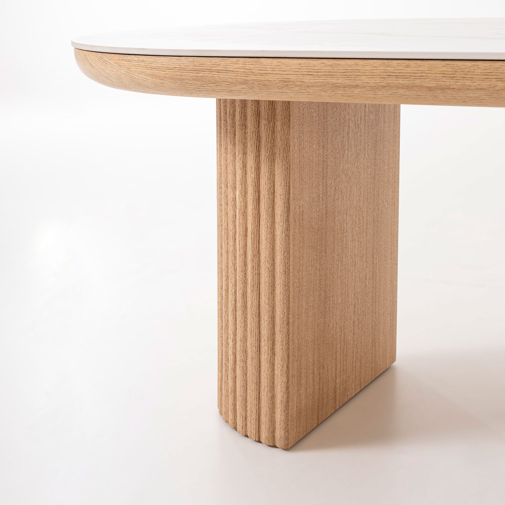Mesa centro Arco ovalada porcelánico blanco, base roble acanalada. Lujo sereno, diseño nórdico minimalista. Medidas: 120x60x45 cm.