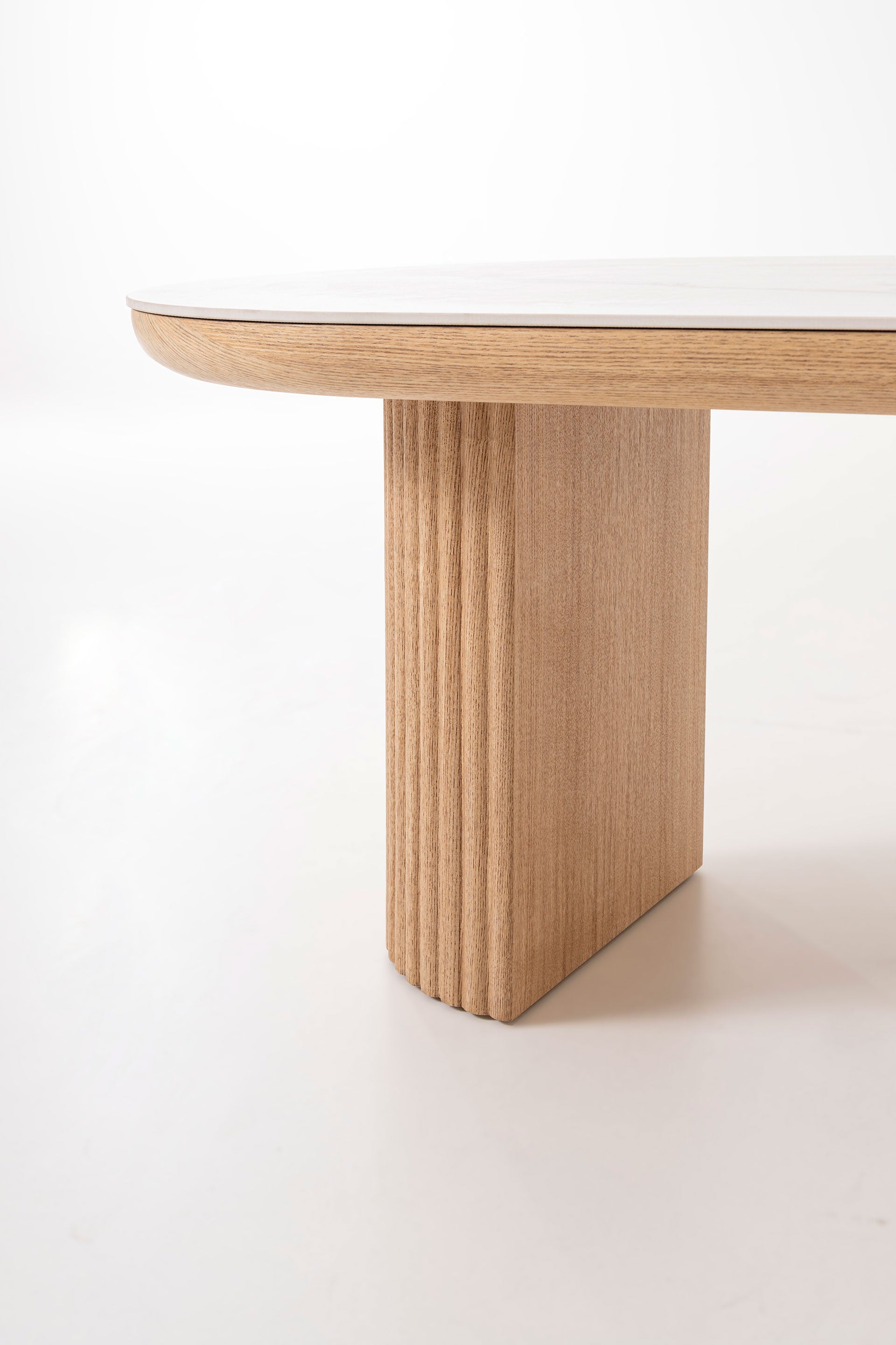 Mesa centro Arco ovalada porcelánico blanco, base roble acanalada. Lujo sereno, diseño nórdico minimalista. Medidas: 120x60x45 cm.